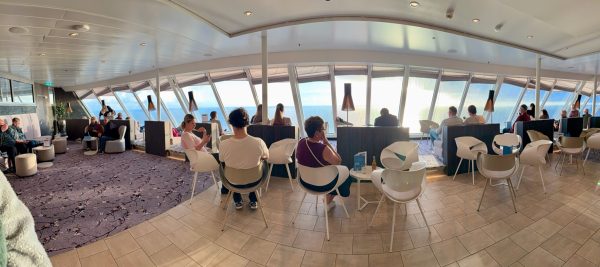 Panorama-Lounge an Bord mit umlaufender Fensterfront und Blick aufs Meer.